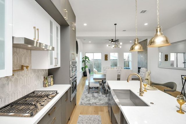 kitchen with visible vents, modern cabinets, light countertops, light wood-style floors, and stainless steel gas cooktop