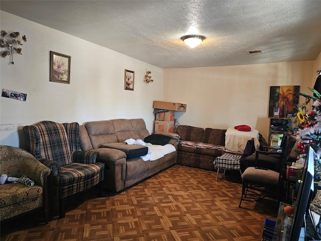 living area with visible vents and a textured ceiling