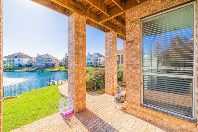 view of patio / terrace featuring a residential view, a water view, and fence