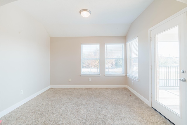 unfurnished room with lofted ceiling, carpet floors, and baseboards