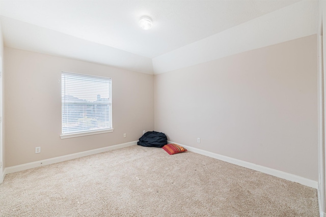 carpeted empty room with lofted ceiling and baseboards