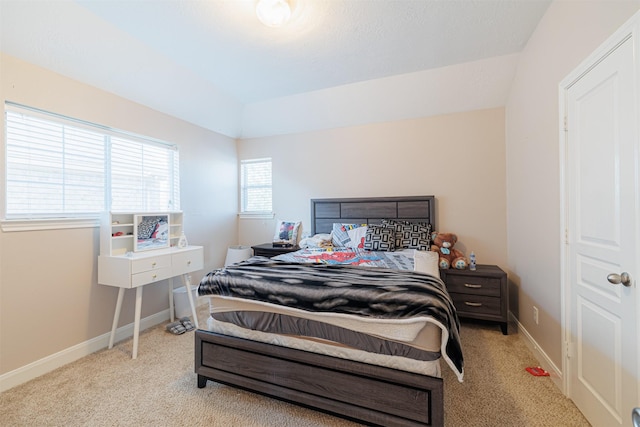 carpeted bedroom with baseboards and vaulted ceiling