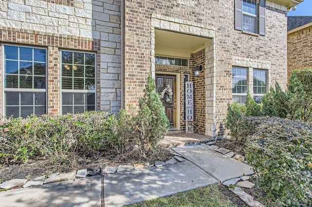 view of exterior entry with brick siding