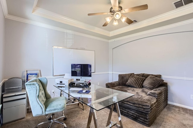 carpeted office with crown molding, a tray ceiling, visible vents, and ceiling fan