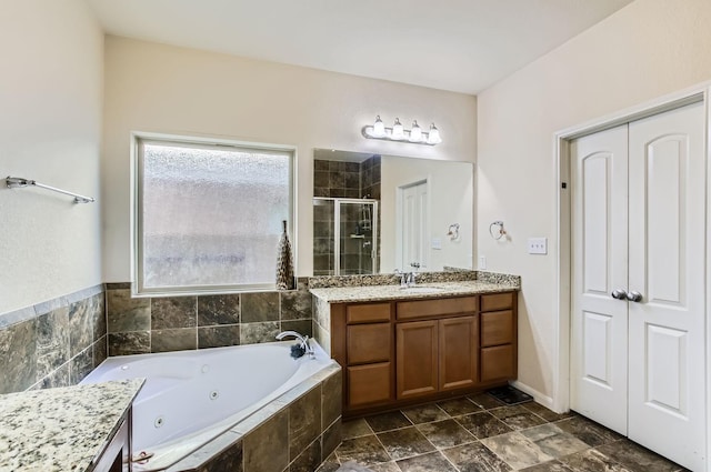 full bath with a stall shower, a jetted tub, and vanity