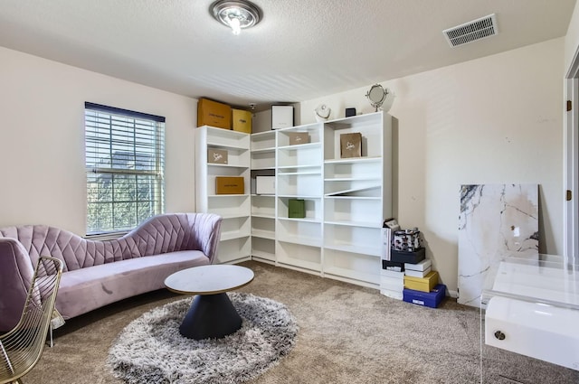 sitting room featuring a textured ceiling, carpet, and visible vents