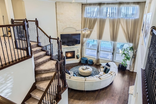 living area with stairway, a fireplace, wood-type flooring, and a wealth of natural light