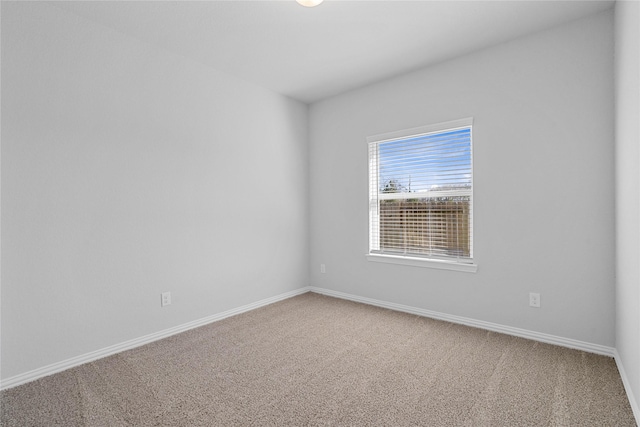 carpeted empty room featuring baseboards