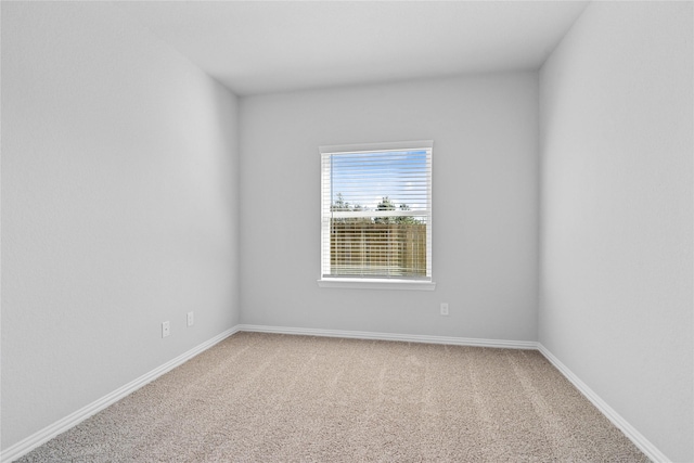 carpeted spare room featuring baseboards