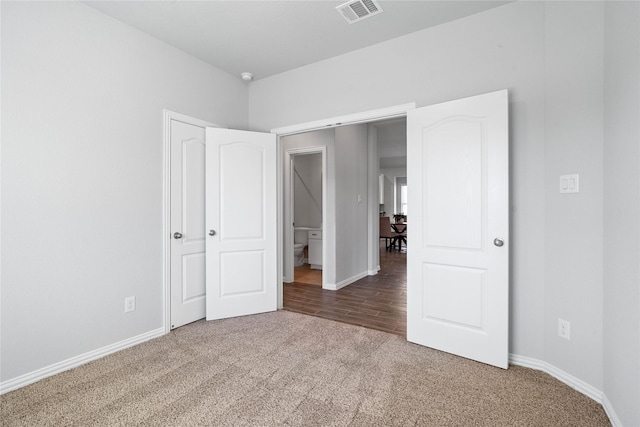 unfurnished bedroom with carpet, visible vents, and baseboards