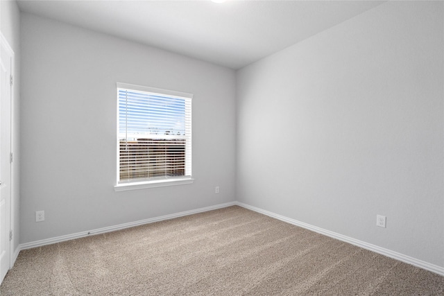 carpeted spare room with baseboards