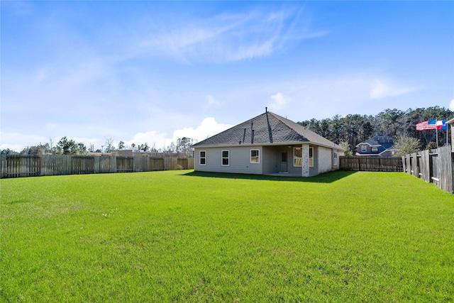 back of house featuring a lawn and a fenced backyard