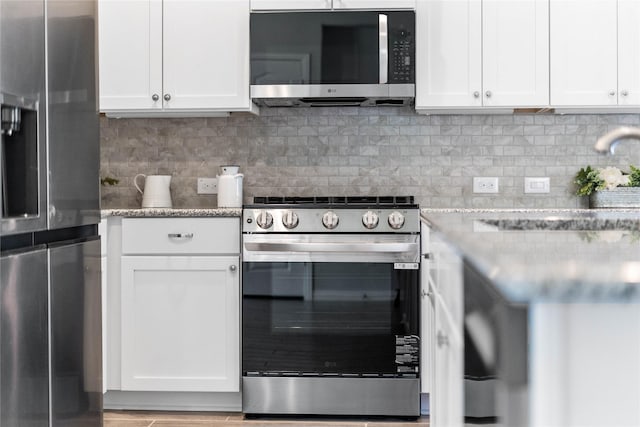 kitchen with stainless steel appliances, white cabinetry, a sink, and decorative backsplash