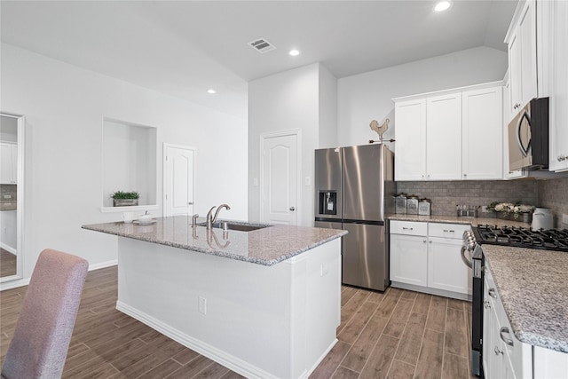 kitchen featuring stainless steel appliances, wood finished floors, a sink, and visible vents