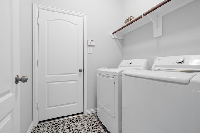 laundry area with laundry area, independent washer and dryer, tile patterned flooring, and baseboards