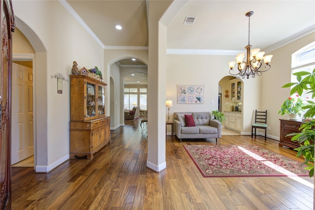 foyer entrance featuring dark wood-style floors, a wealth of natural light, visible vents, and baseboards