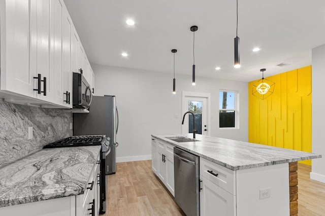 kitchen featuring white cabinets, backsplash, stainless steel appliances, and a sink