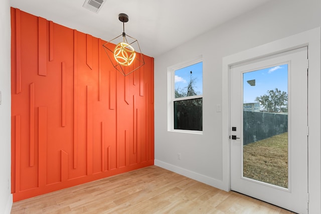 doorway to outside with visible vents, plenty of natural light, and light wood finished floors