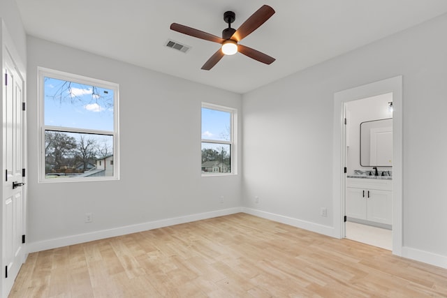 unfurnished bedroom featuring light wood-type flooring, baseboards, multiple windows, and visible vents