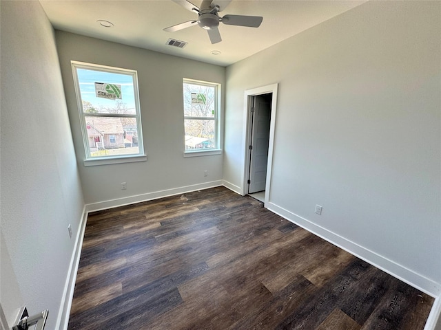 unfurnished bedroom featuring a ceiling fan, visible vents, baseboards, and dark wood-type flooring