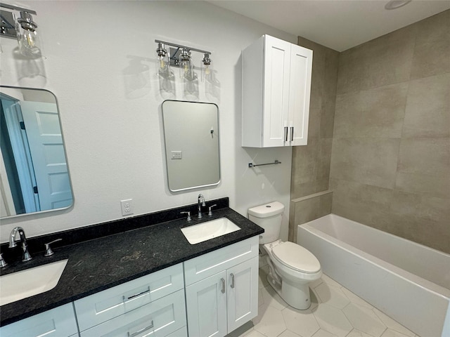 full bath with toilet, double vanity, a sink, and tile patterned floors