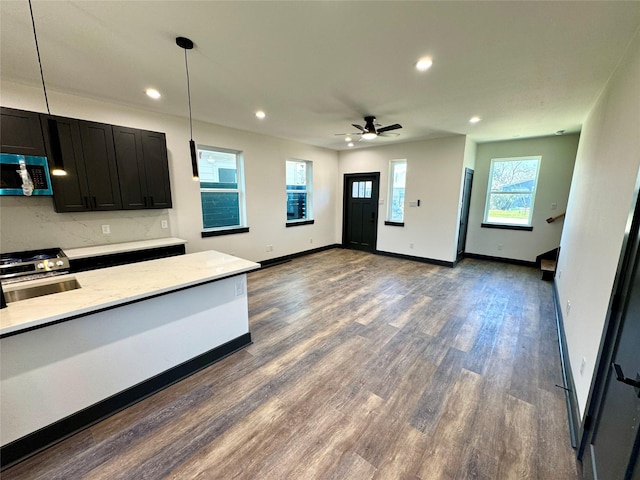 kitchen featuring dark wood-type flooring, recessed lighting, stainless steel microwave, and baseboards