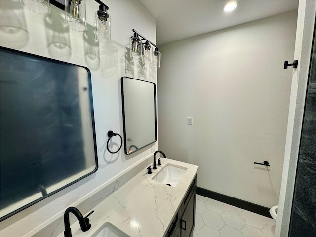 bathroom with toilet, tile patterned floors, vanity, and baseboards