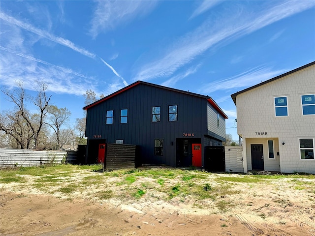 back of property with fence and board and batten siding