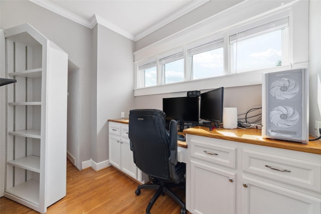 office featuring ornamental molding, built in desk, light wood-style flooring, and baseboards