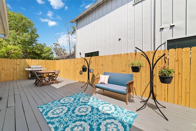 wooden deck with outdoor dining area, fence, and area for grilling