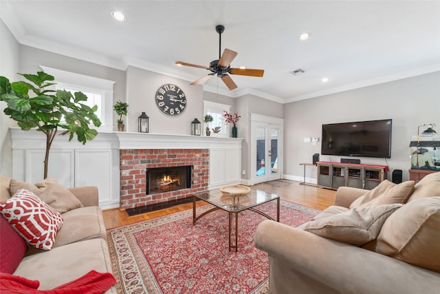 living area with recessed lighting, visible vents, crown molding, and wood finished floors