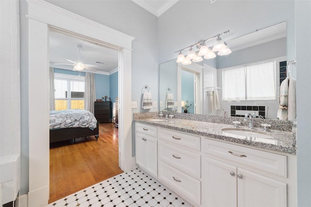 ensuite bathroom featuring double vanity, crown molding, connected bathroom, and a sink