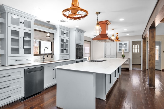 kitchen with a center island, island exhaust hood, visible vents, stainless steel dishwasher, and a sink