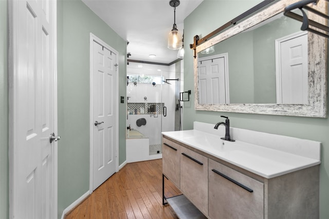 bathroom featuring wood-type flooring, a shower stall, and vanity