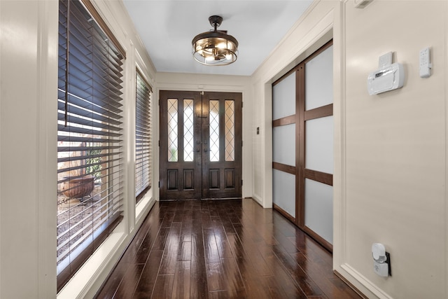 foyer entrance with baseboards, dark wood-type flooring, and french doors