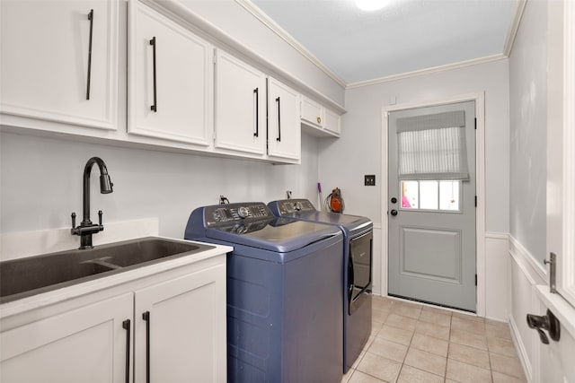 clothes washing area featuring crown molding, washer and clothes dryer, light tile patterned floors, cabinet space, and a sink