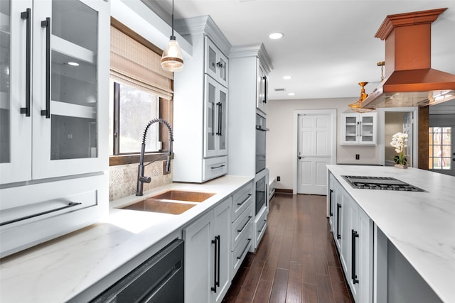 kitchen featuring hanging light fixtures, a sink, island exhaust hood, stainless steel gas cooktop, and backsplash