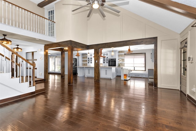 unfurnished living room featuring a wealth of natural light, stairs, and wood finished floors