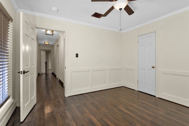 spare room featuring a wainscoted wall, dark wood finished floors, and crown molding