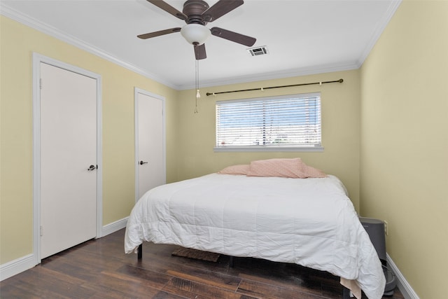 bedroom with crown molding, visible vents, ceiling fan, wood finished floors, and baseboards