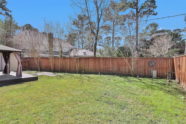 view of yard with a deck, a gazebo, and a fenced backyard