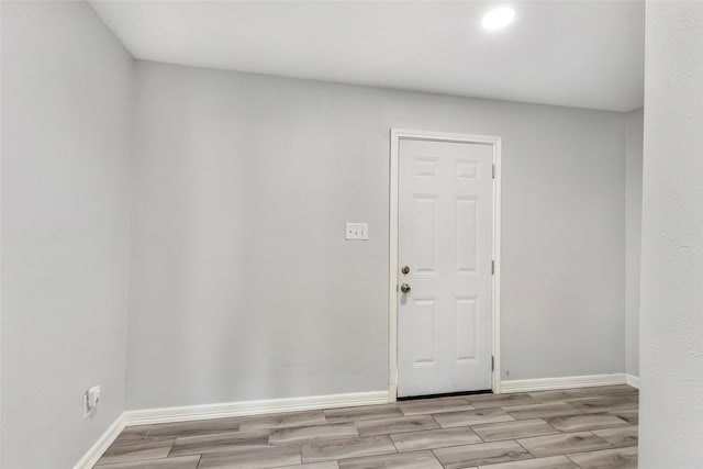 spare room featuring wood finish floors and baseboards