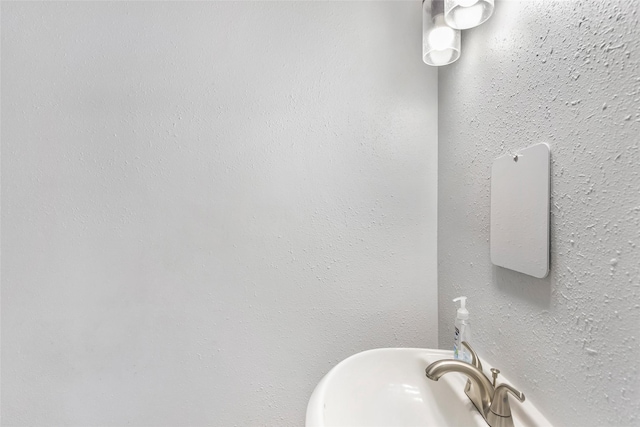 bathroom featuring a sink and a textured wall