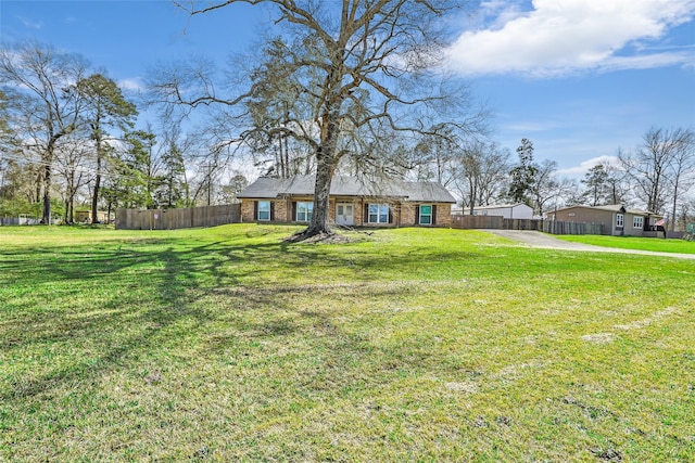 view of front of house featuring fence, a front lawn, and brick siding