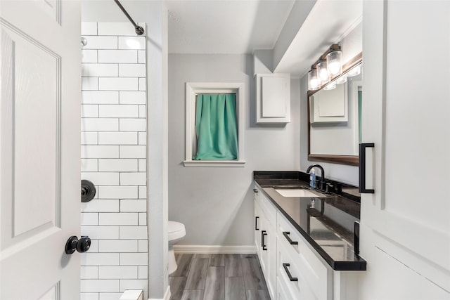 bathroom featuring baseboards, vanity, toilet, and wood finished floors