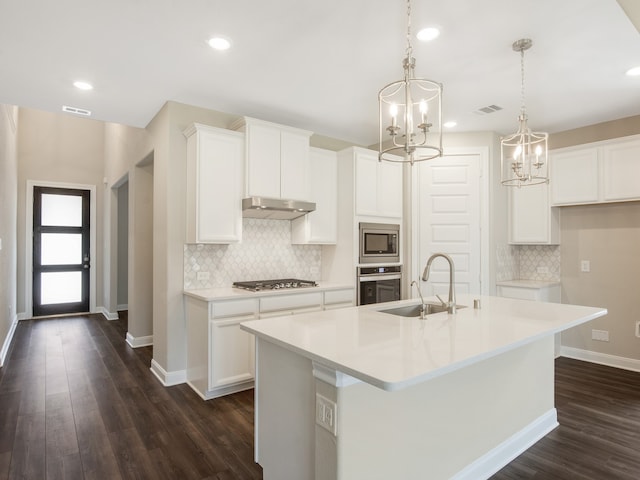 kitchen with visible vents, an island with sink, appliances with stainless steel finishes, under cabinet range hood, and a sink