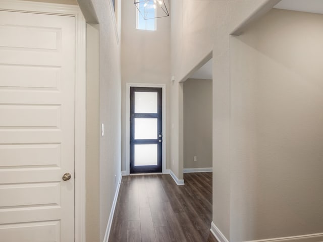 entryway with dark wood-style floors, baseboards, and an inviting chandelier