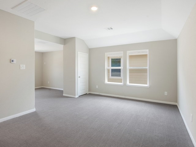 empty room featuring lofted ceiling, baseboards, and visible vents