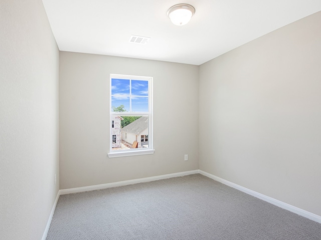 carpeted spare room with baseboards and visible vents