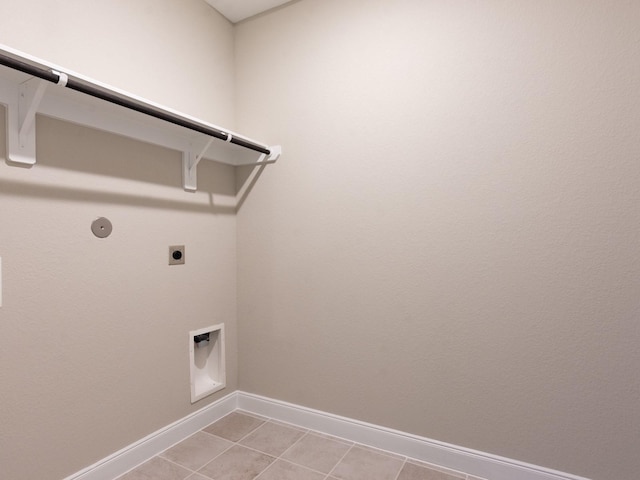 laundry area featuring light tile patterned floors, hookup for a gas dryer, electric dryer hookup, laundry area, and baseboards